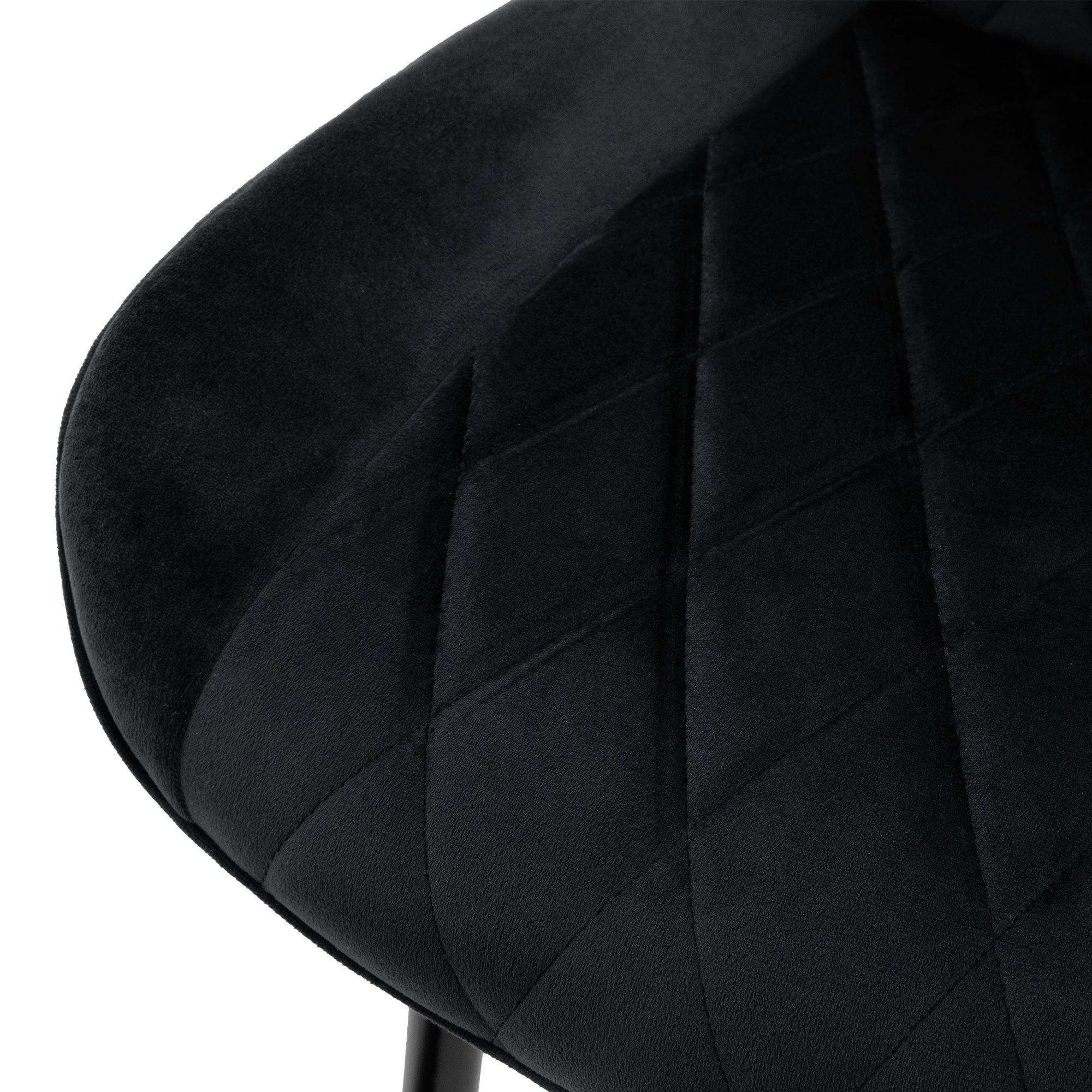 Gros plan de l'assise d'une chaise noire avec un rembourrage en forme de diamant.