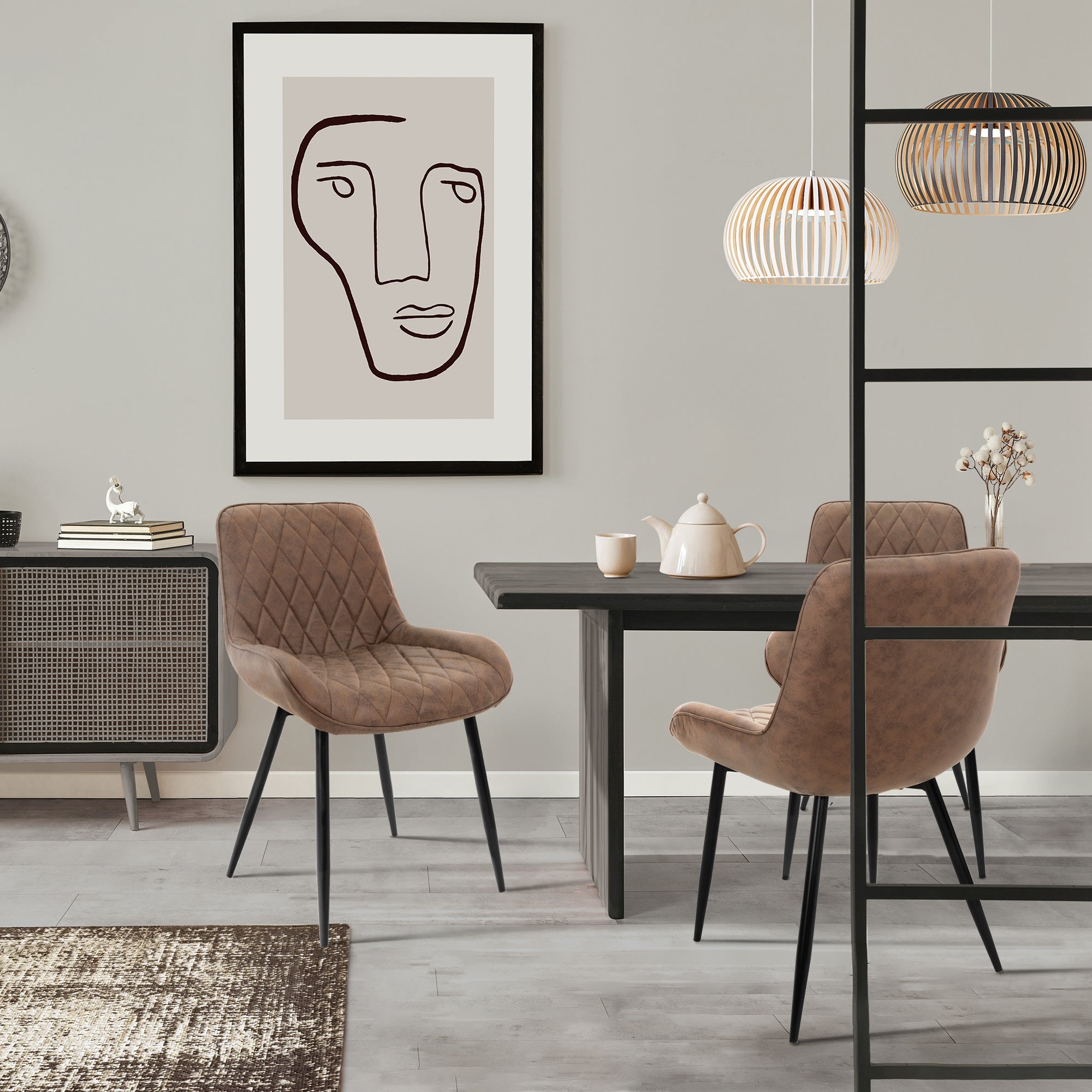 Comedor con sillas marrones, mesa, tetera y arte en la pared.
