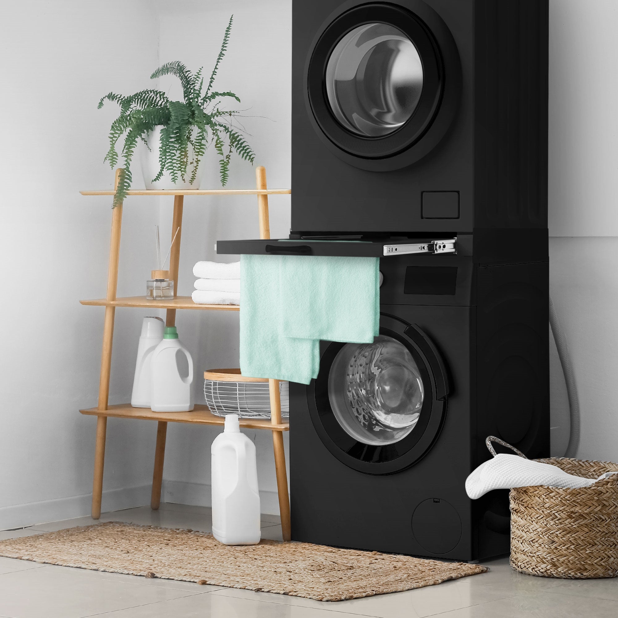 Washing machine with shelf, towel, and plants on a shelf.