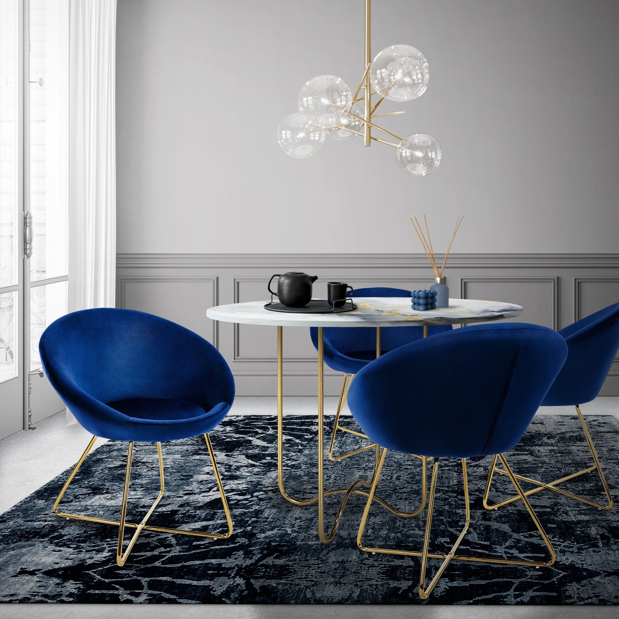 Zona pranzo con poltrona blu, tavolo e lampadario in un ambiente moderno.