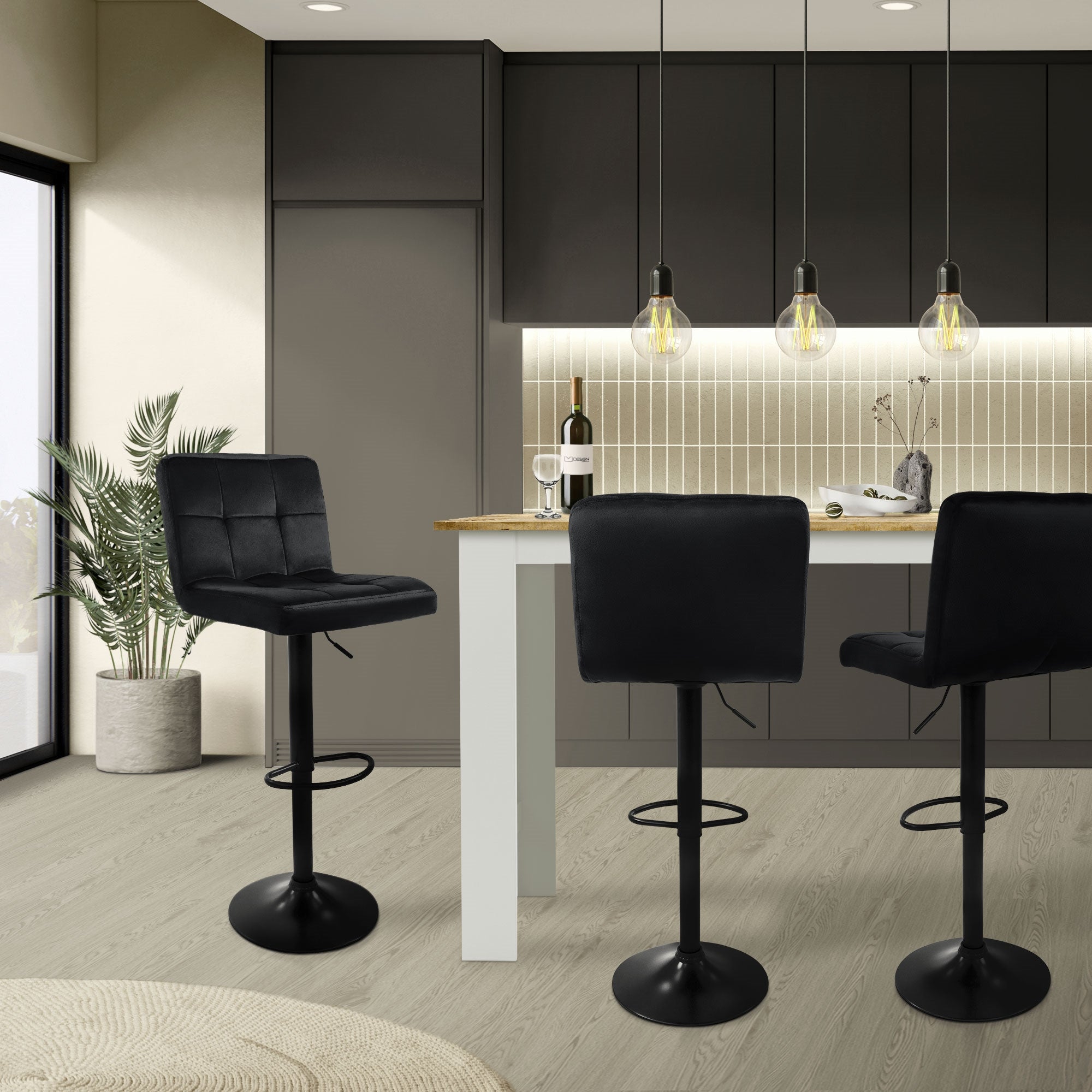 Cocina moderna con tres taburetes de bar negros y una barra blanca.