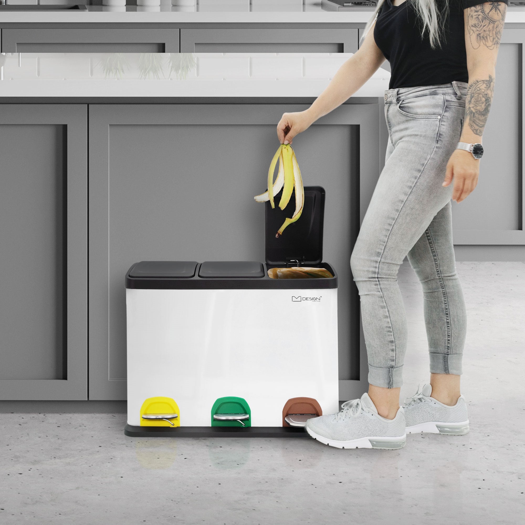 Person with long hair throwing a banana into a waste separation container.