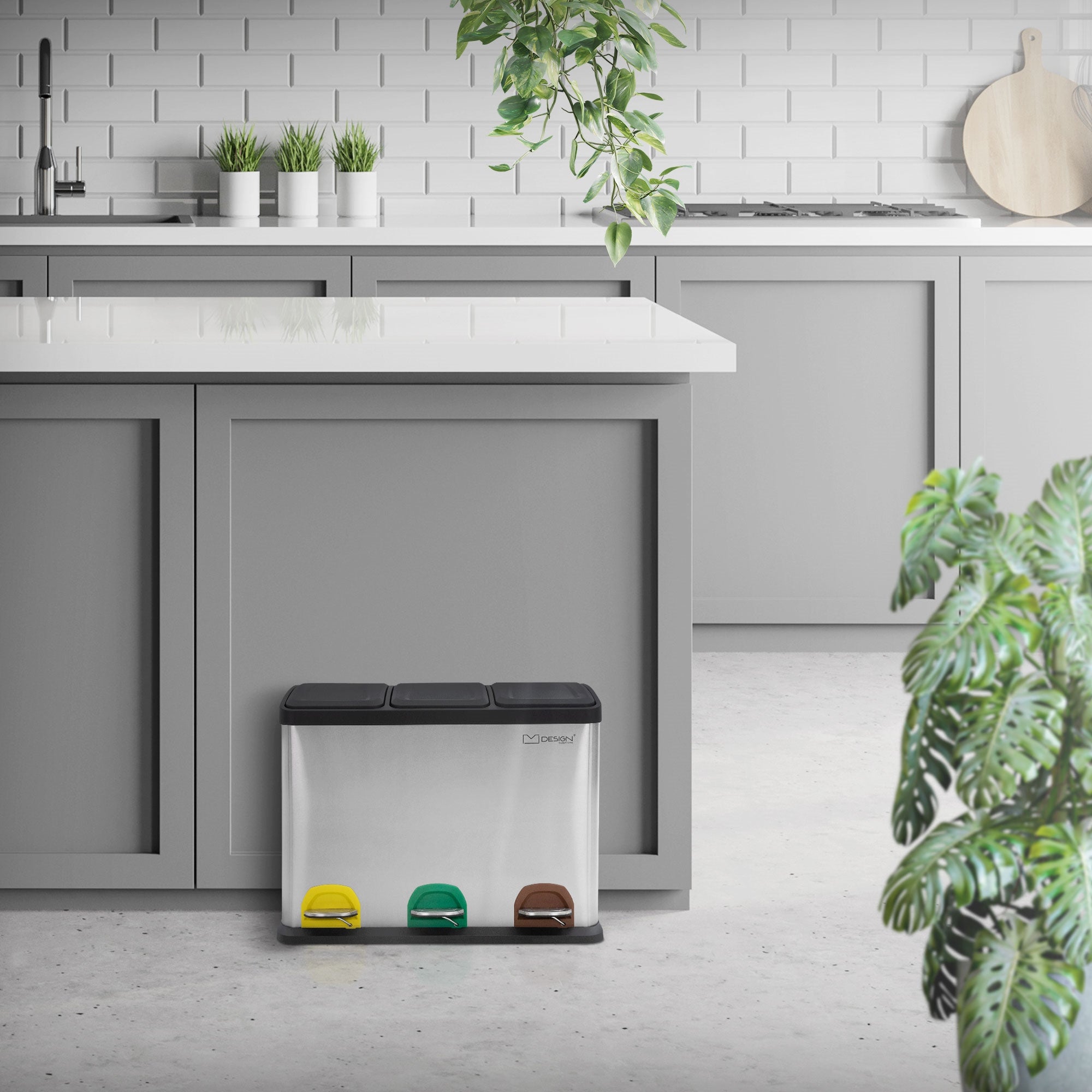 Mülltrennungssystem in einer modernen Küche mit Pflanzen und hellem Interieur.