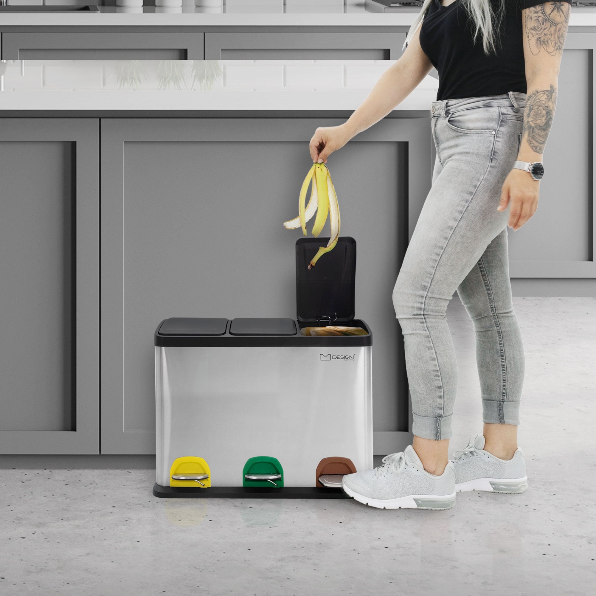 Person öffnet Mülleimer mit Fußpedal in einer modernen Küche.