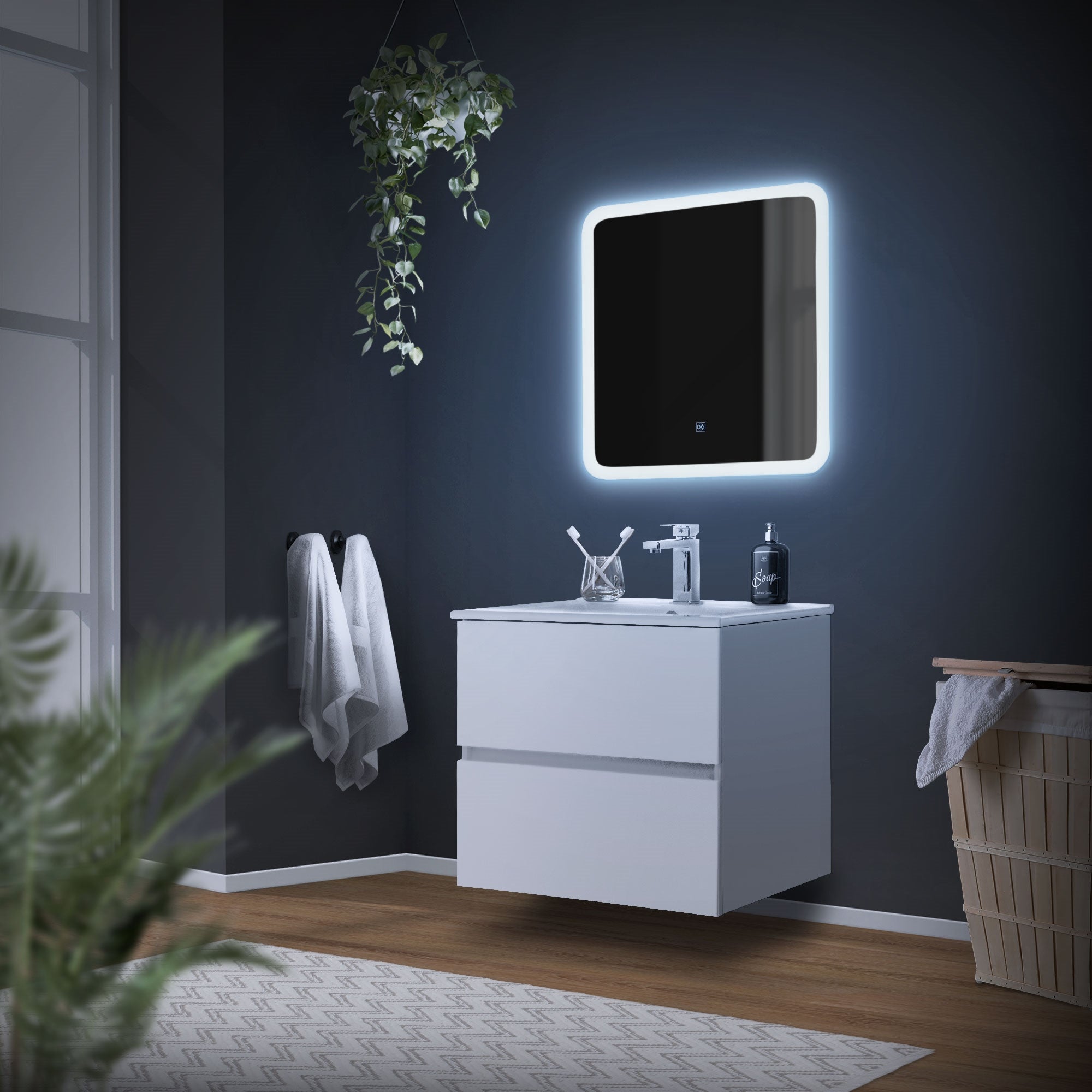 Bagno con specchio illuminato, lavabo e asciugamani.