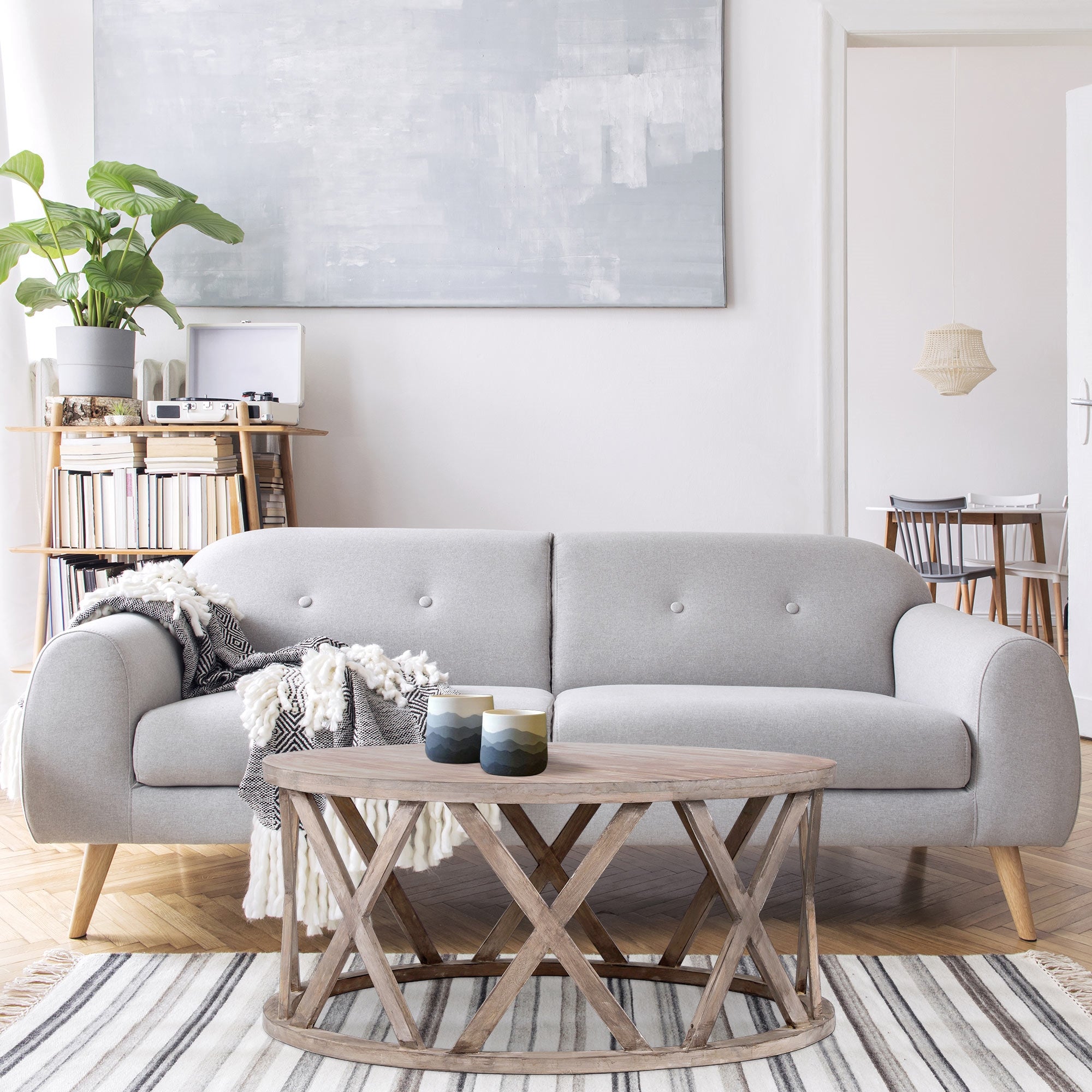 Hyggelig stue med grå sofa, sofabord og planter.