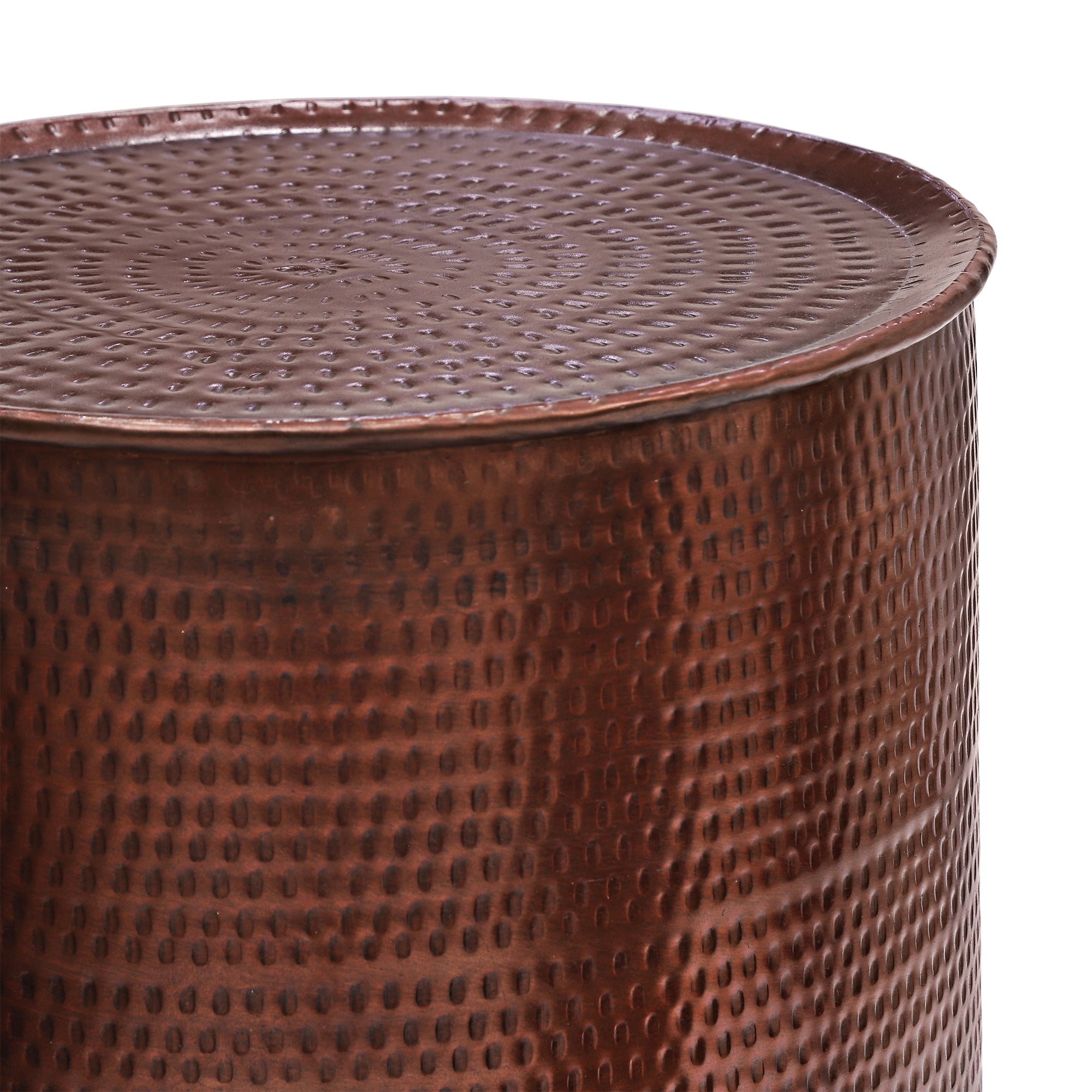 Round, copper-colored side table with patterned surface.